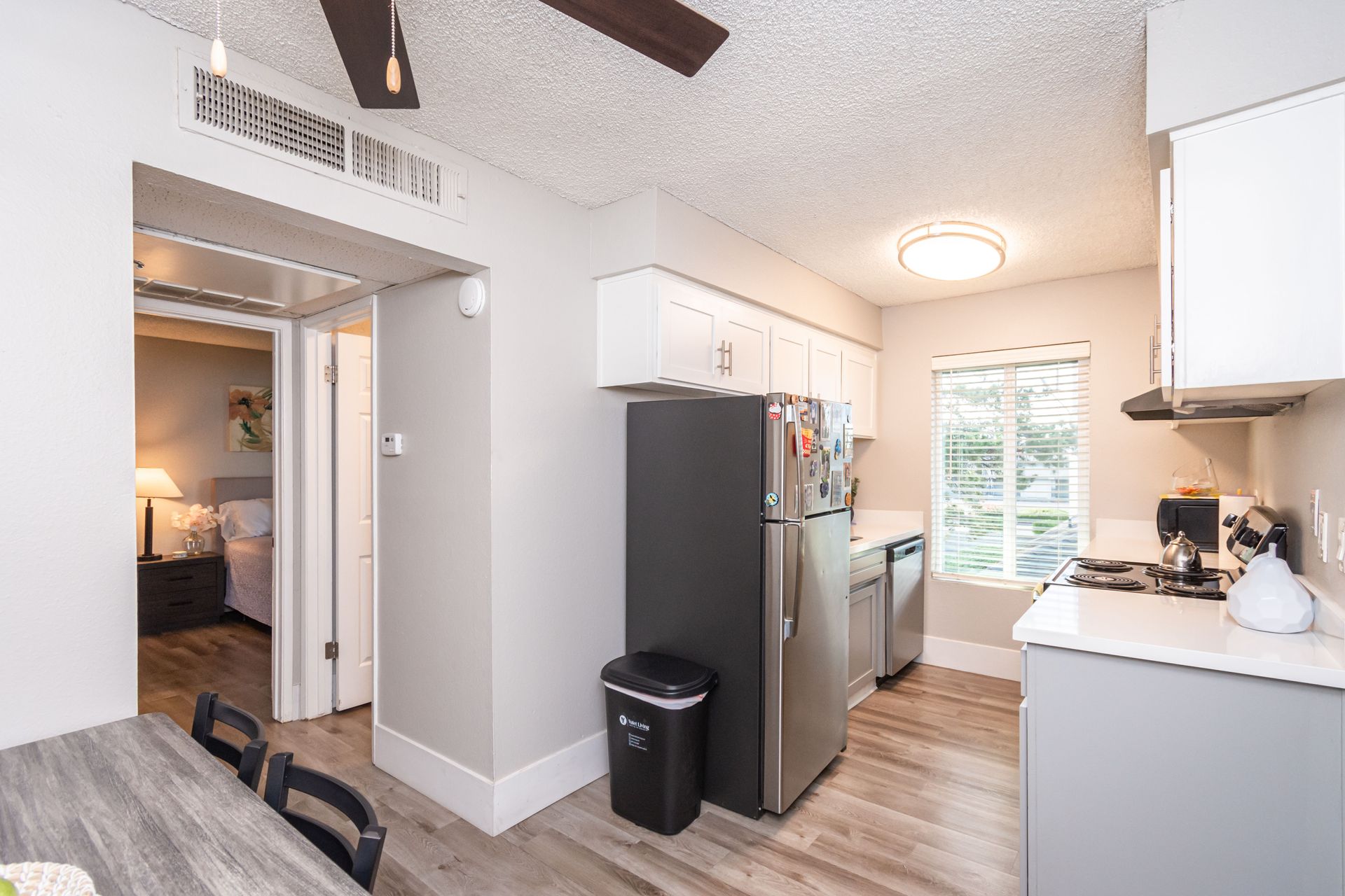 A kitchen with stainless steel appliances and a ceiling fan.