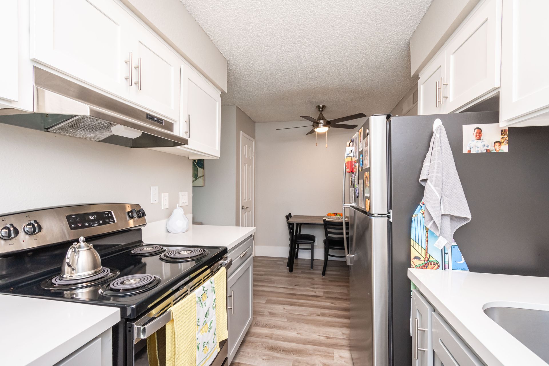 A kitchen with stainless steel appliances and white cabinets