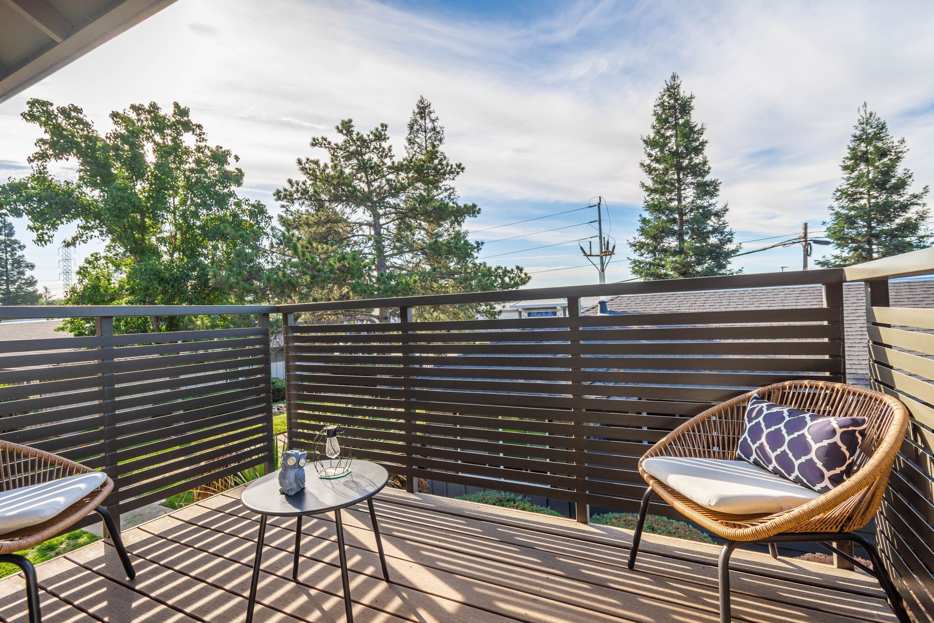 There are two chairs and a table on the balcony.