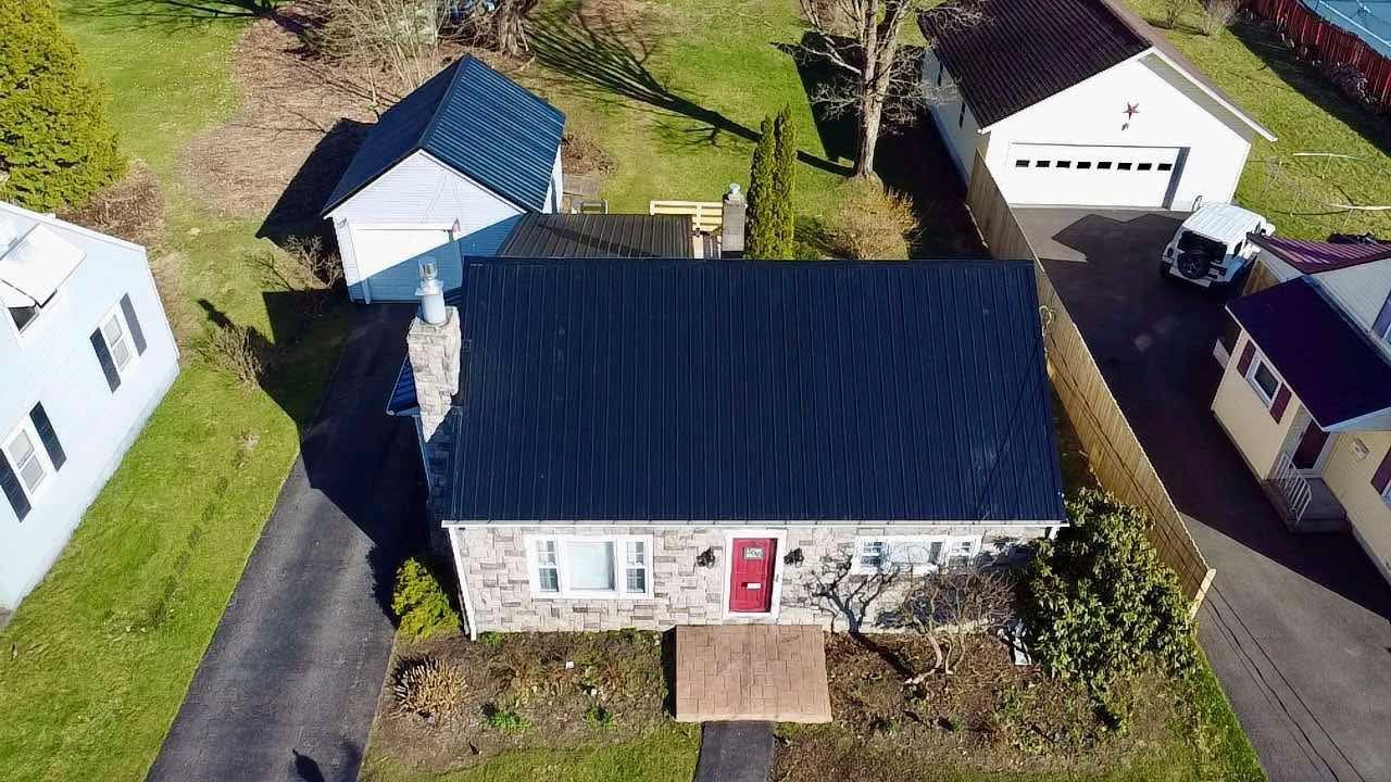 An aerial view of a house with a blue roof and a red door