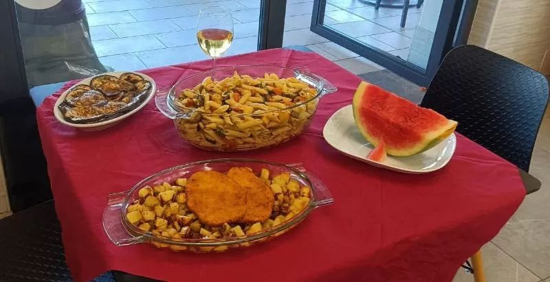 pasto completo: pasta con verdure, cotolette di pollo con patate al forno, contorno di melanzane grigliate e anguria