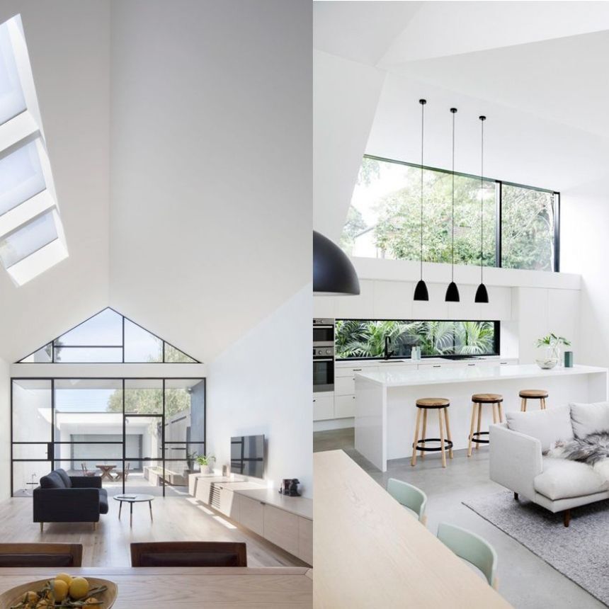 Salón y cocina modernos y luminosos con paredes blancas, grandes ventanales y muebles minimalistas.