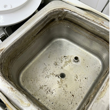 Dirty stainless steel sink basin with stains and two drain holes.