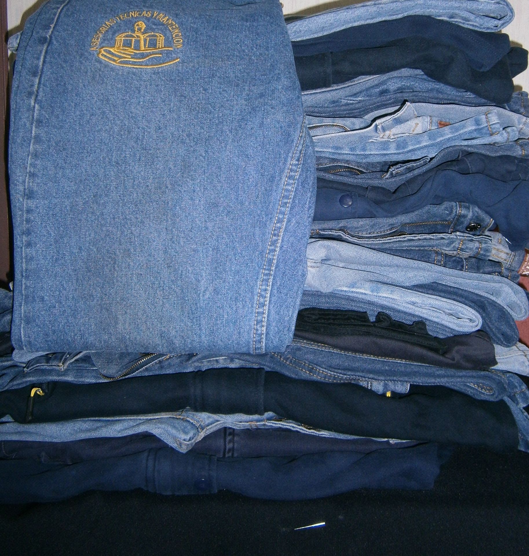 Una pila de pantalones vaqueros azules doblados en diferentes tonalidades de mezclilla