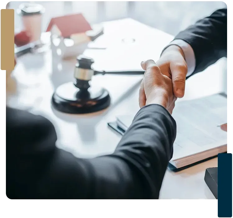 Two men are shaking hands over a table with a gavel in the background.