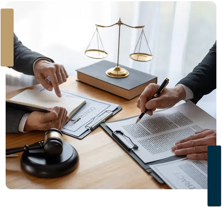 Two men are sitting at a table with a judge 's gavel and scales of justice.