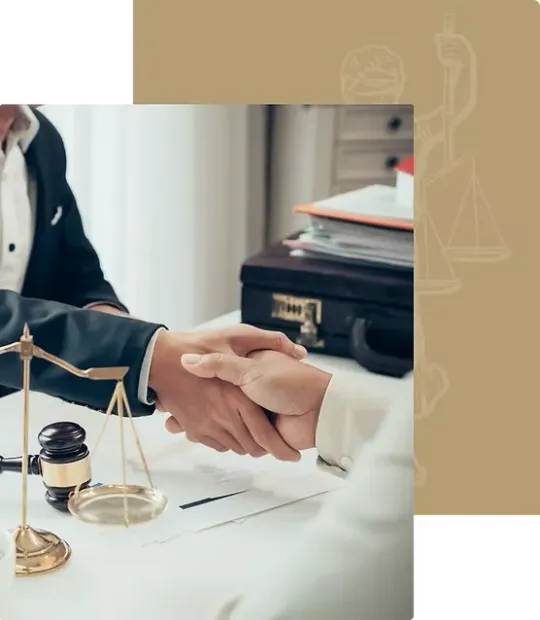 A man and woman are shaking hands at a table with scales of justice.