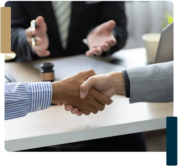 A man in a suit and tie is shaking hands with another man.