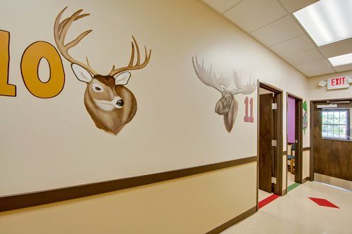 Hallway with deer murals, room number 10, and EXIT sign near a doorway