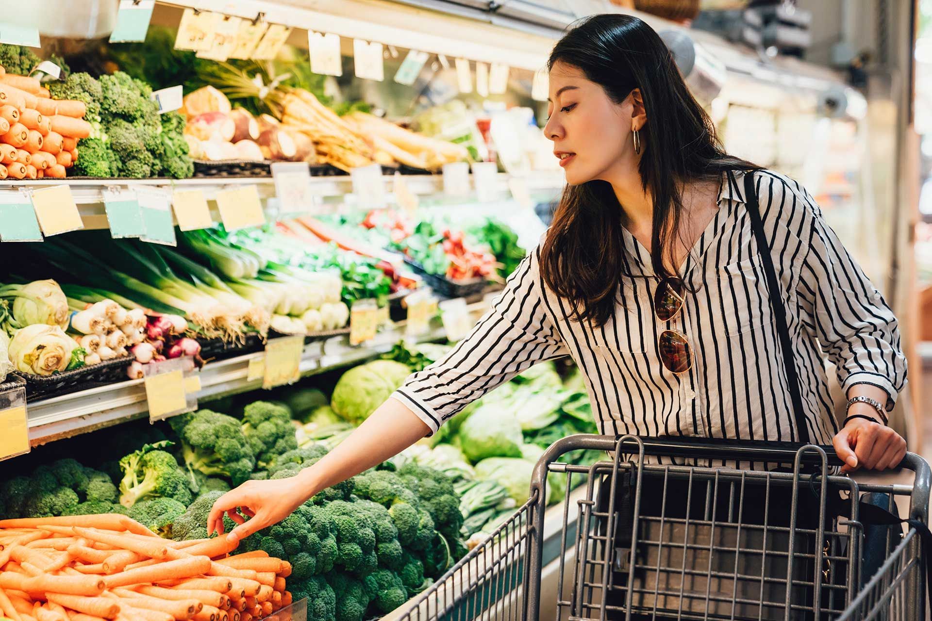woman in supermarket pushing shopping cart
