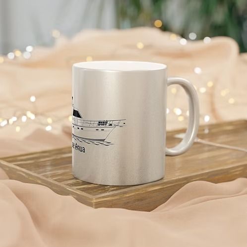 White ceramic mug with black text on a wooden tray, set against a soft beige fabric background with warm lights