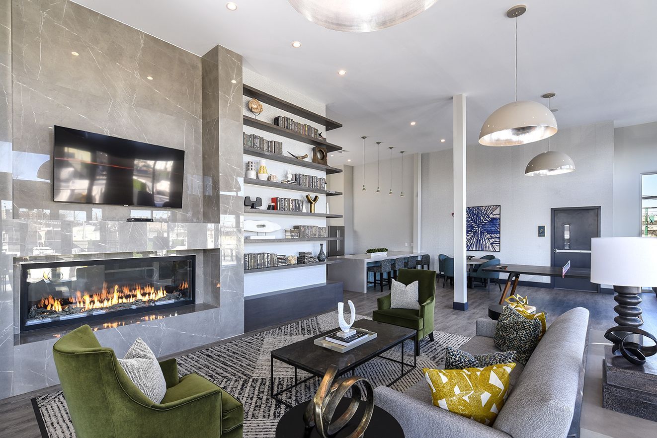 Modern living room with fireplace, built-in shelving, seating, and decorative lighting.
