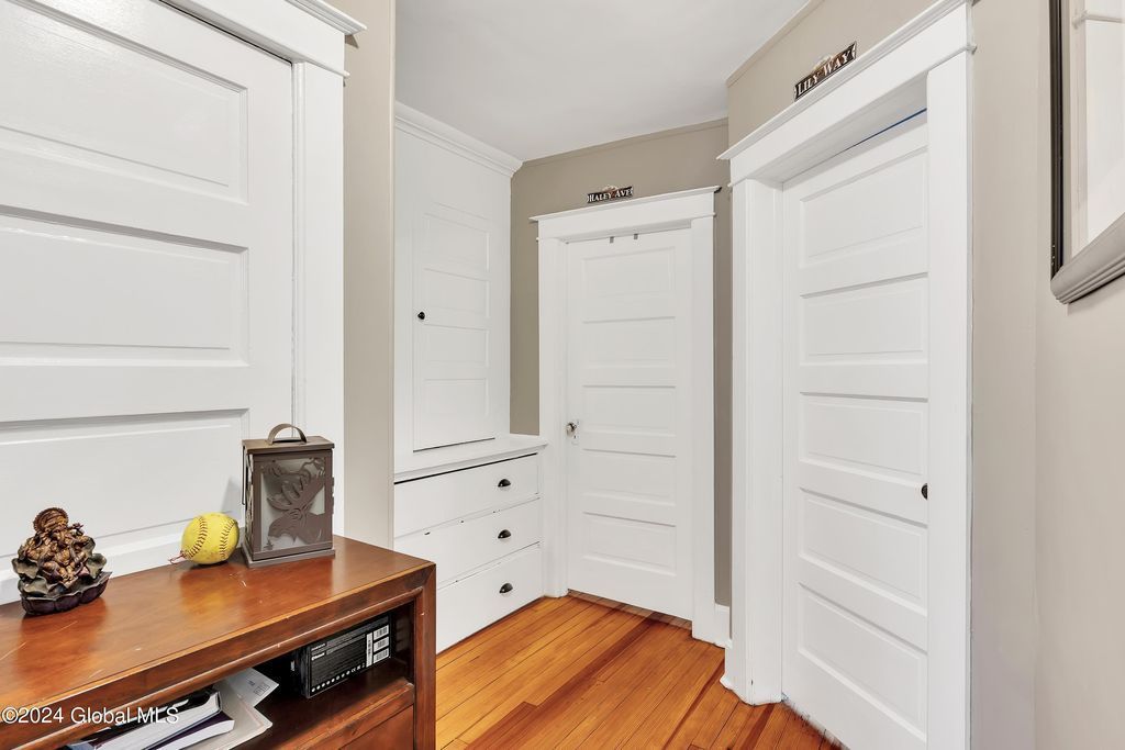 A hallway with hardwood floors and white doors