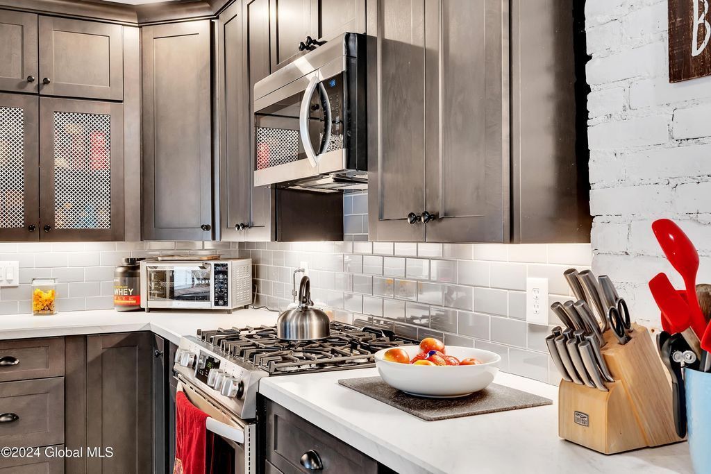 A kitchen with stainless steel appliances and gray cabinets