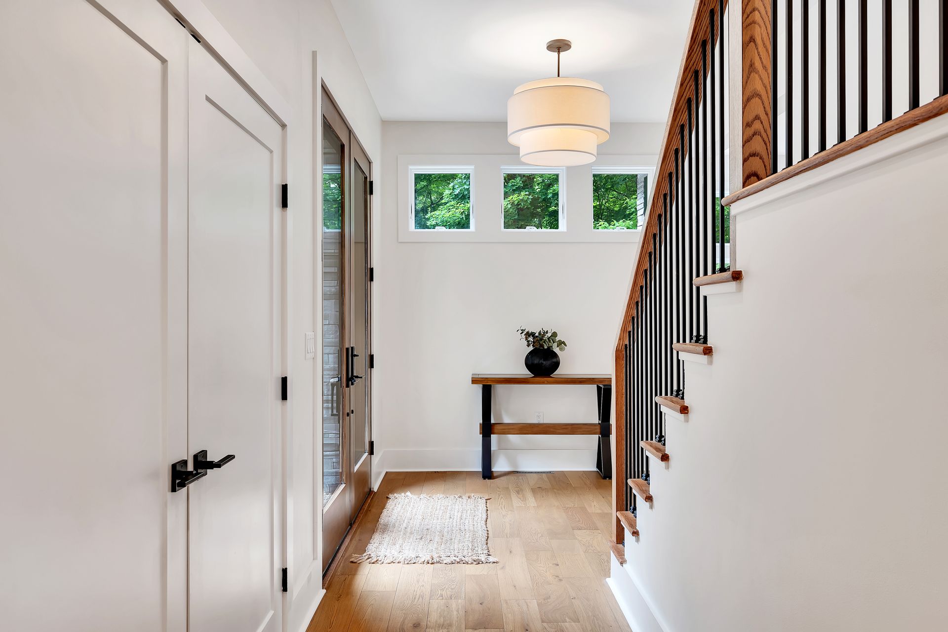 A hallway with stairs and a table in a house.