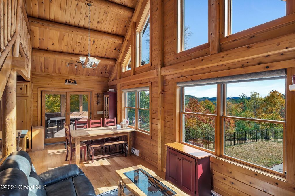 A living room in a log cabin with a lot of windows and a couch.