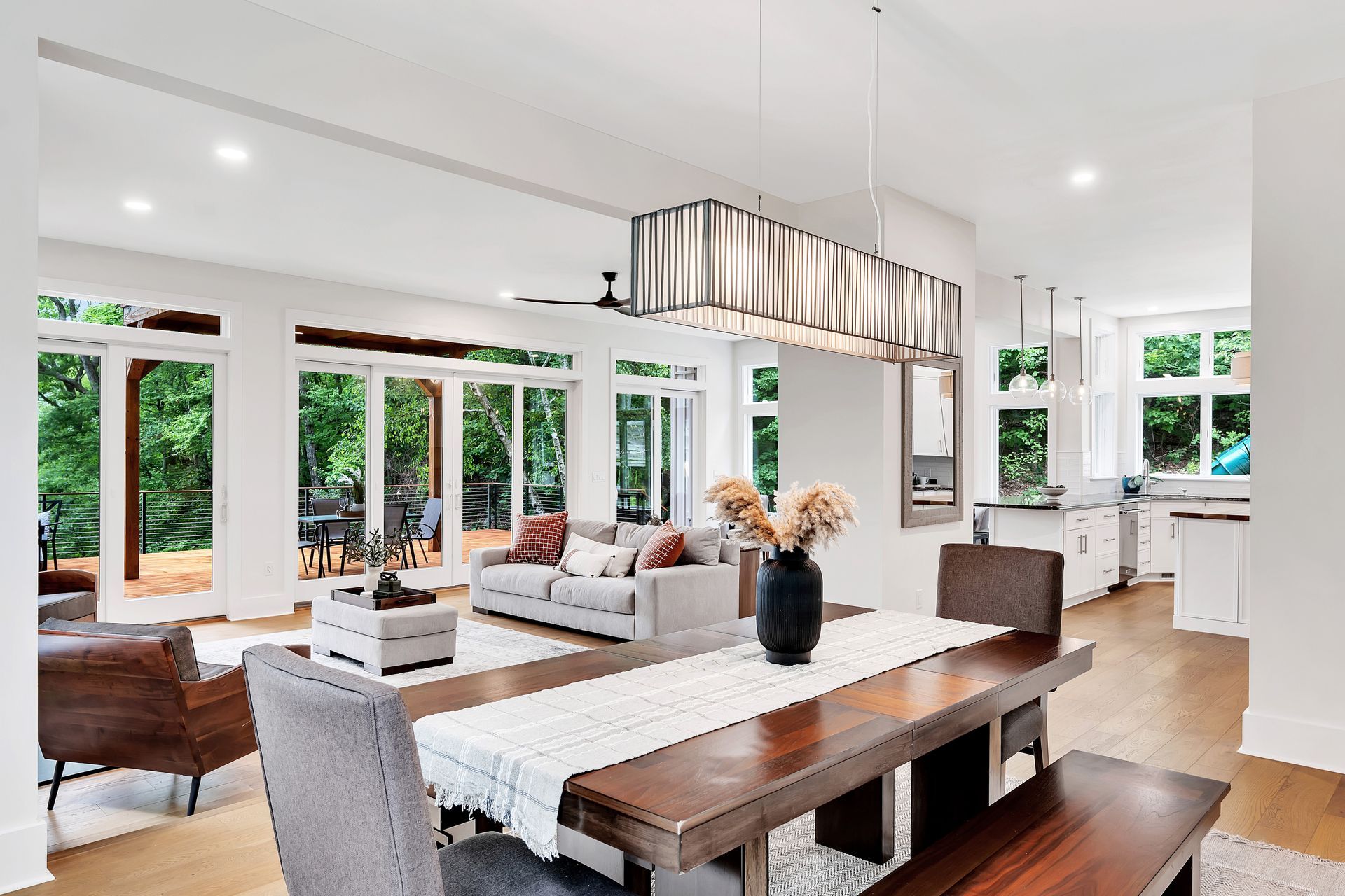 A dining room table with a vase of flowers on it in a living room.
