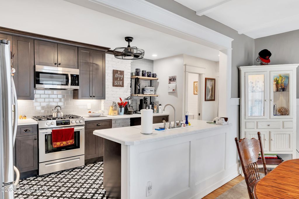 A kitchen with stainless steel appliances , white cabinets , and a large island.