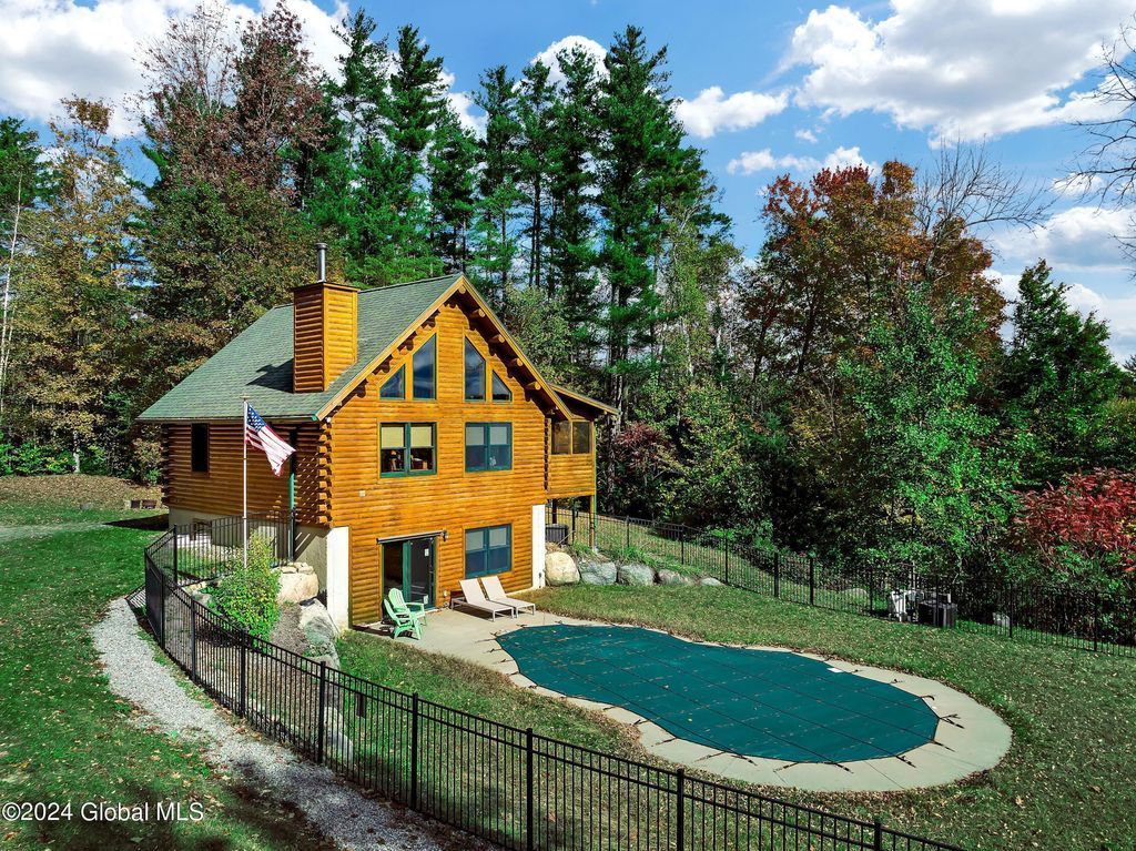 An artist 's impression of a log cabin with a swimming pool