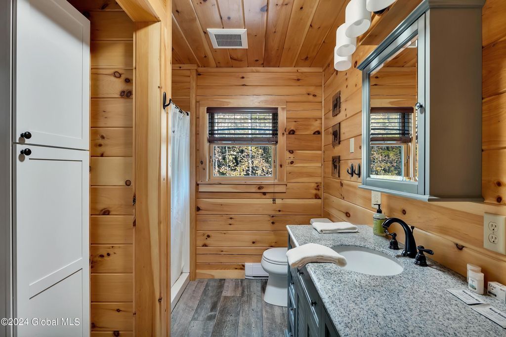 A bathroom in a log cabin with two sinks and a mirror