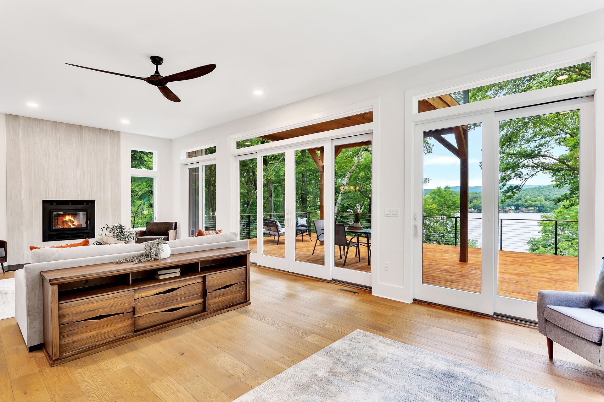 A living room with a lot of windows and a ceiling fan.