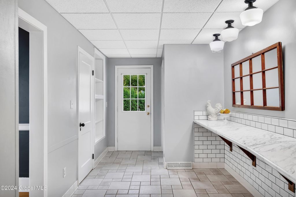 A hallway with a brick floor and a white door