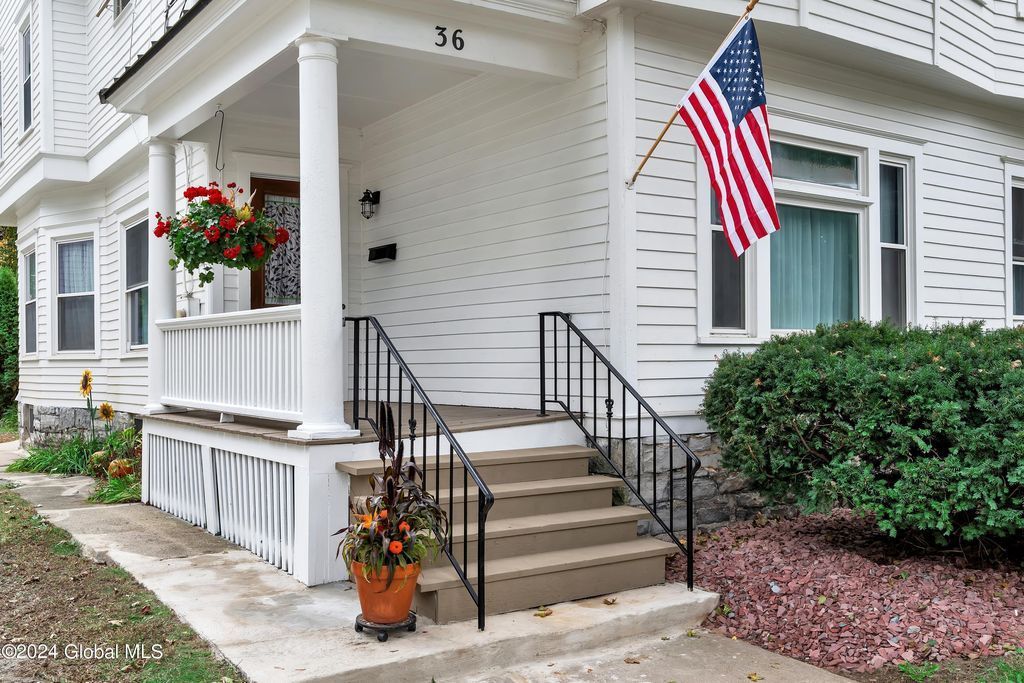 A white house with an american flag on the porch.