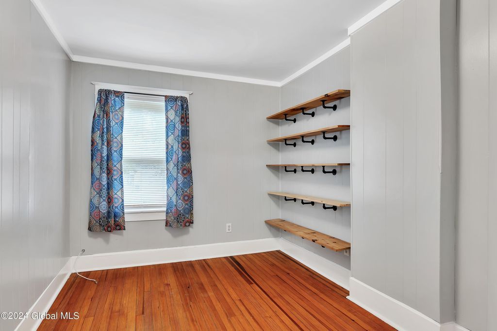An empty room with a wooden floor and shelves