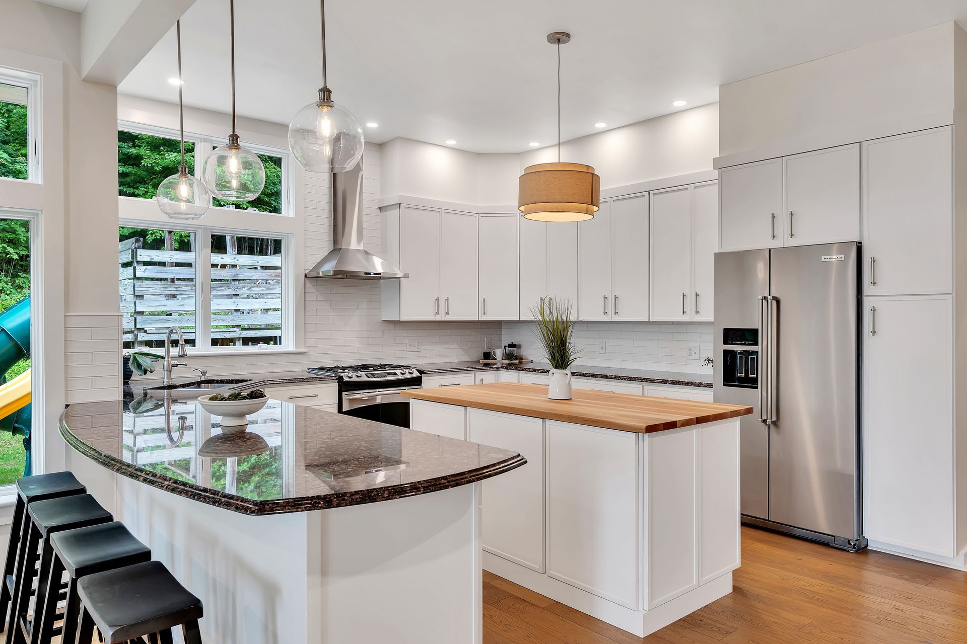 A kitchen with white cabinets and stainless steel appliances and a large island.
