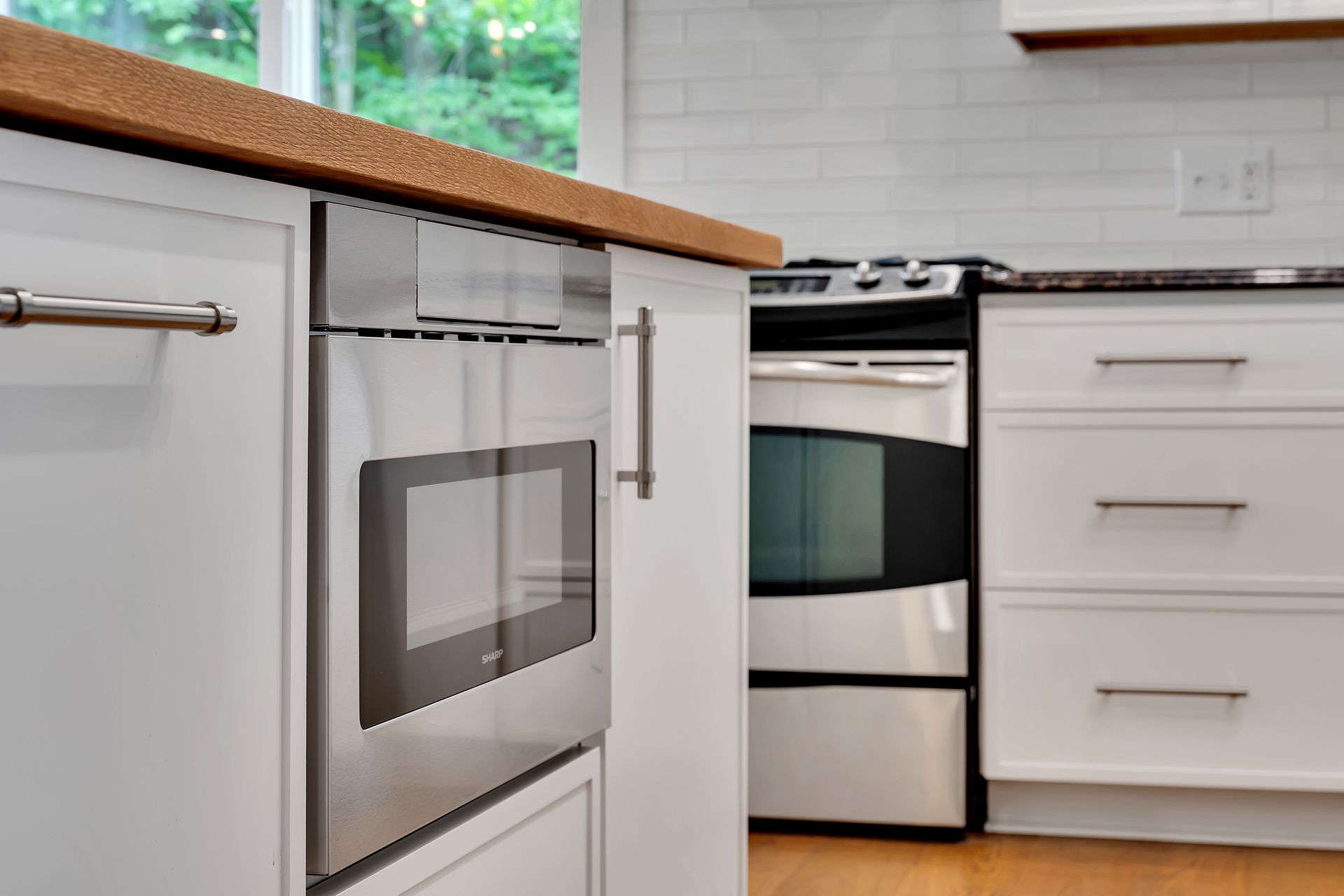 A kitchen with stainless steel appliances and white cabinets.