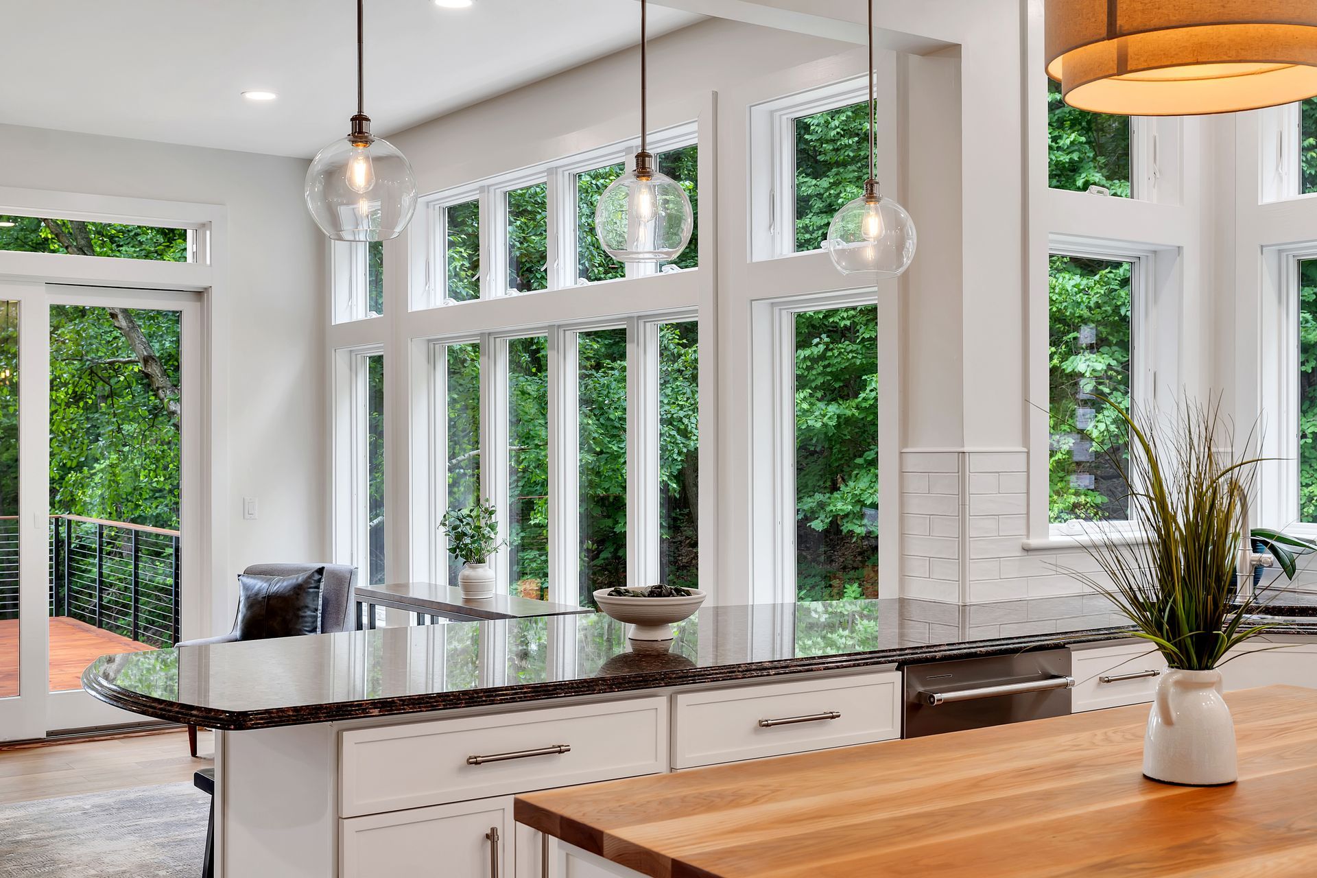 A kitchen with a large island and lots of windows.