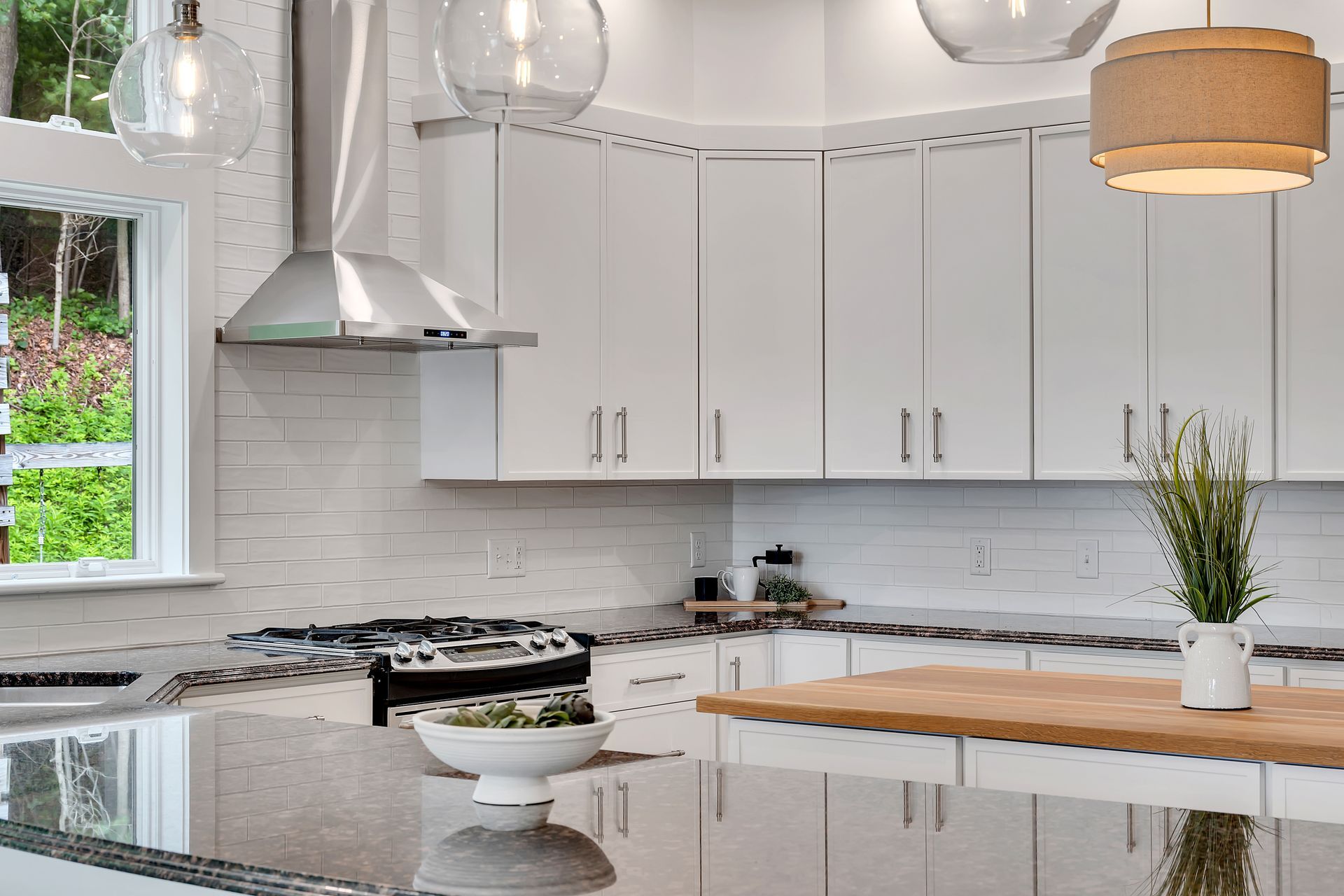 A kitchen with white cabinets and a wooden counter top