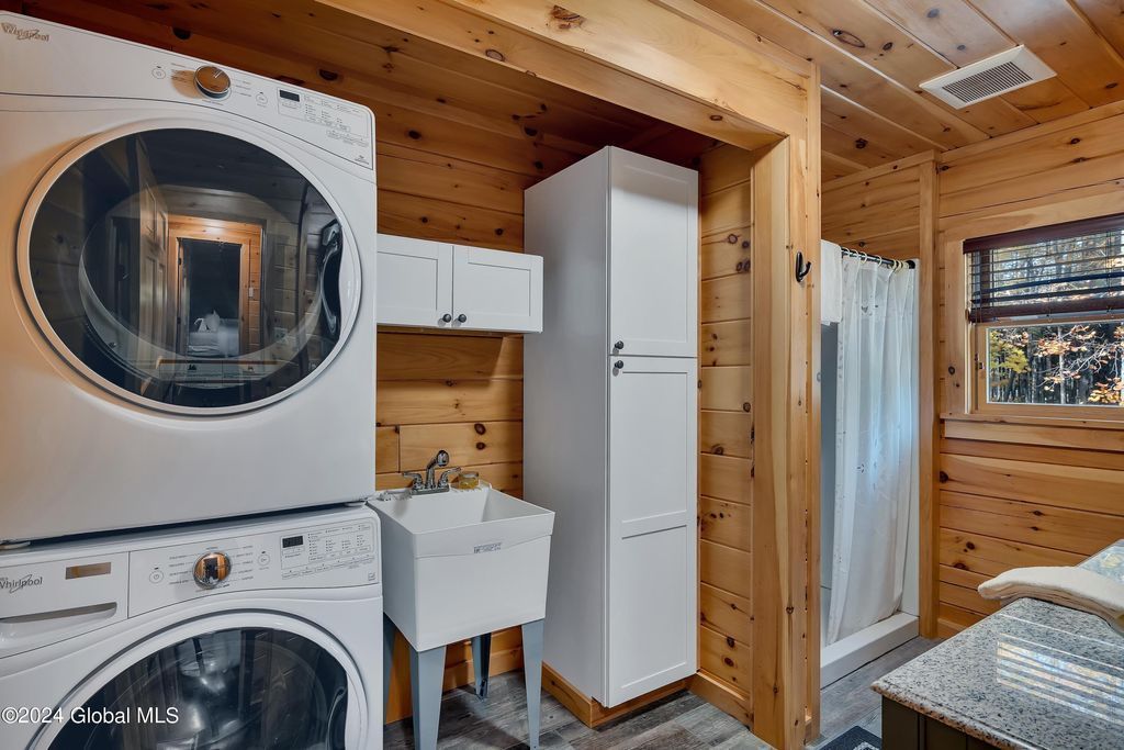 A laundry room with a washer and dryer stacked on top of each other.