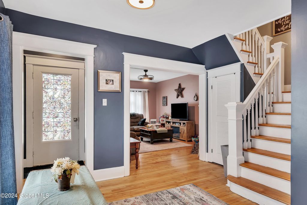 A living room and stairs in a house with blue walls