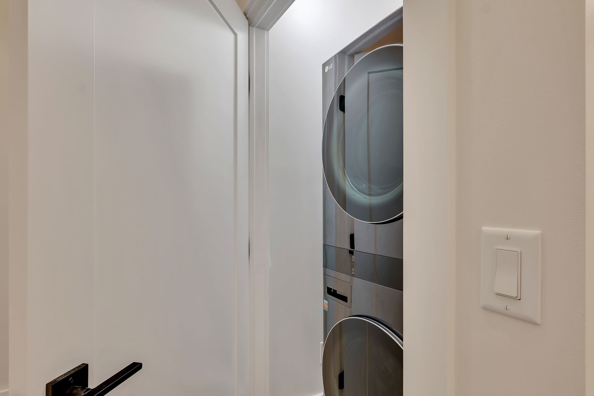 A washer and dryer are stacked on top of each other in a laundry room.