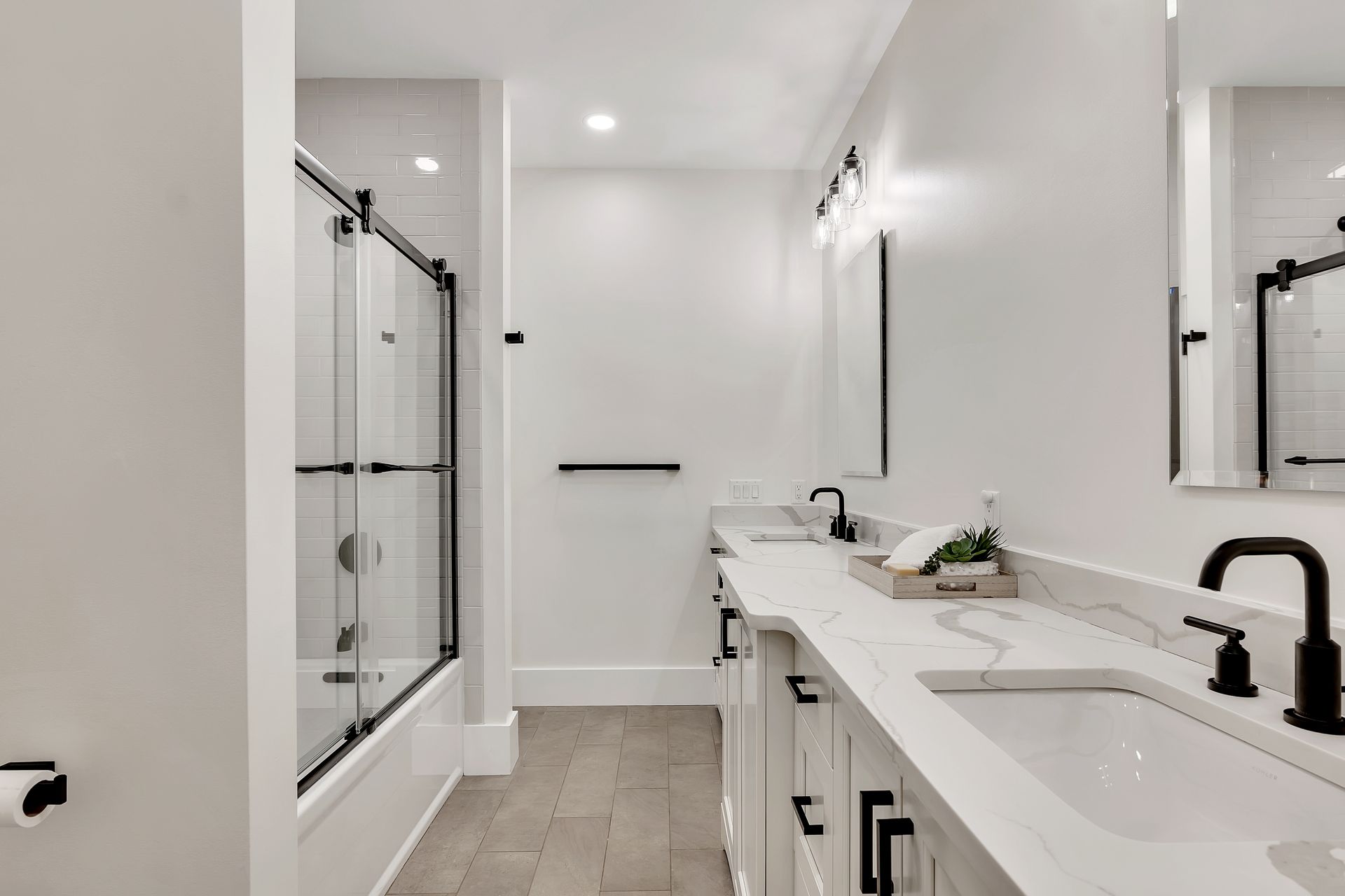 A bathroom with two sinks , a shower and a mirror.
