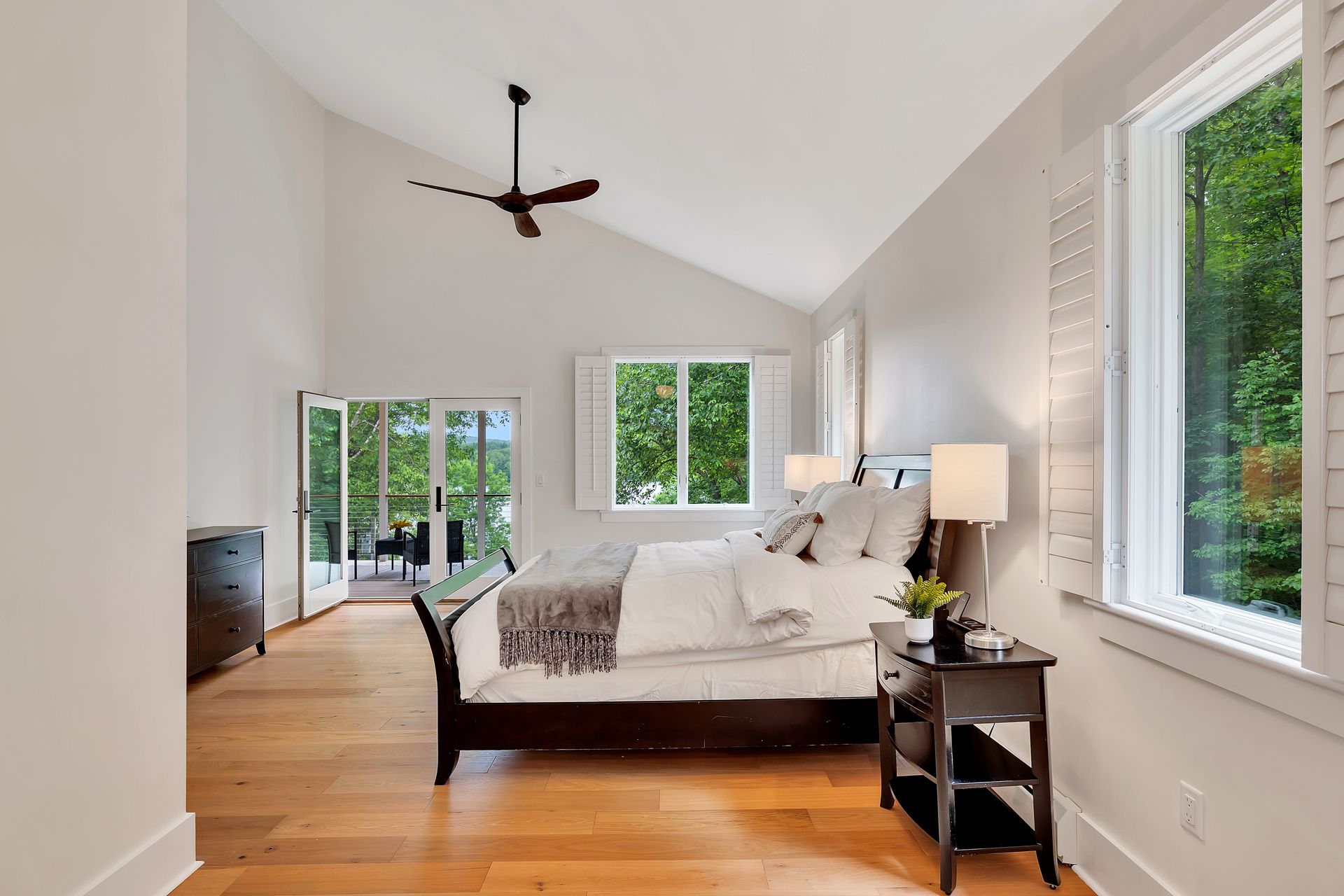 A bedroom with a large bed and a ceiling fan.