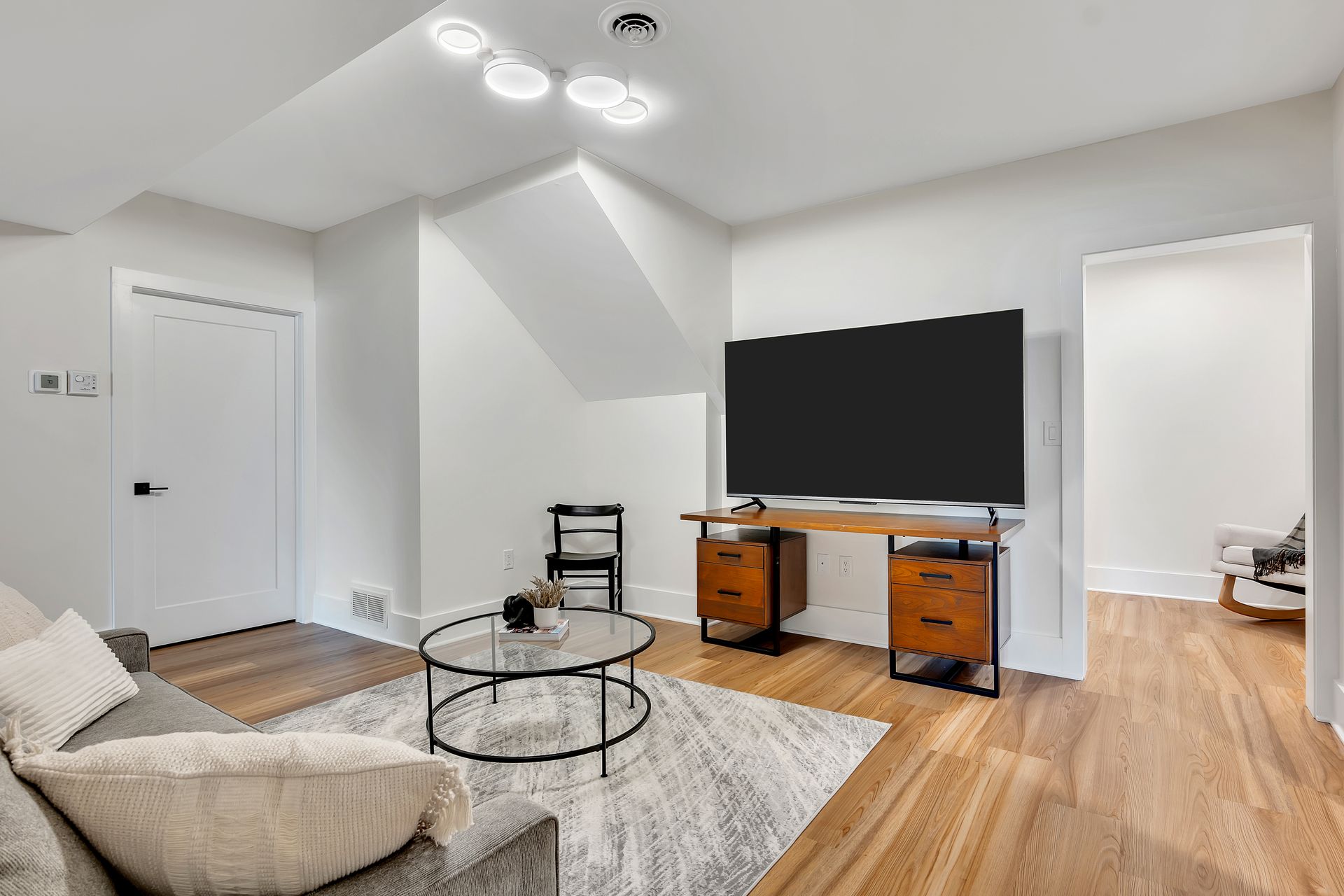 A living room with a couch , desk , and television.