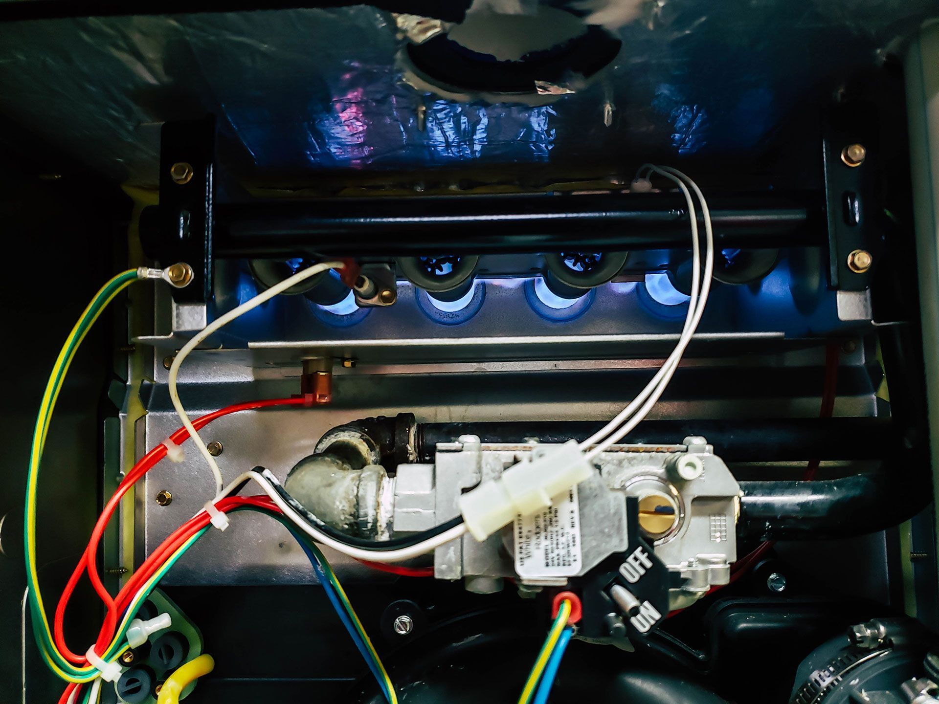 A close up of a stove with a bunch of wires coming out of it