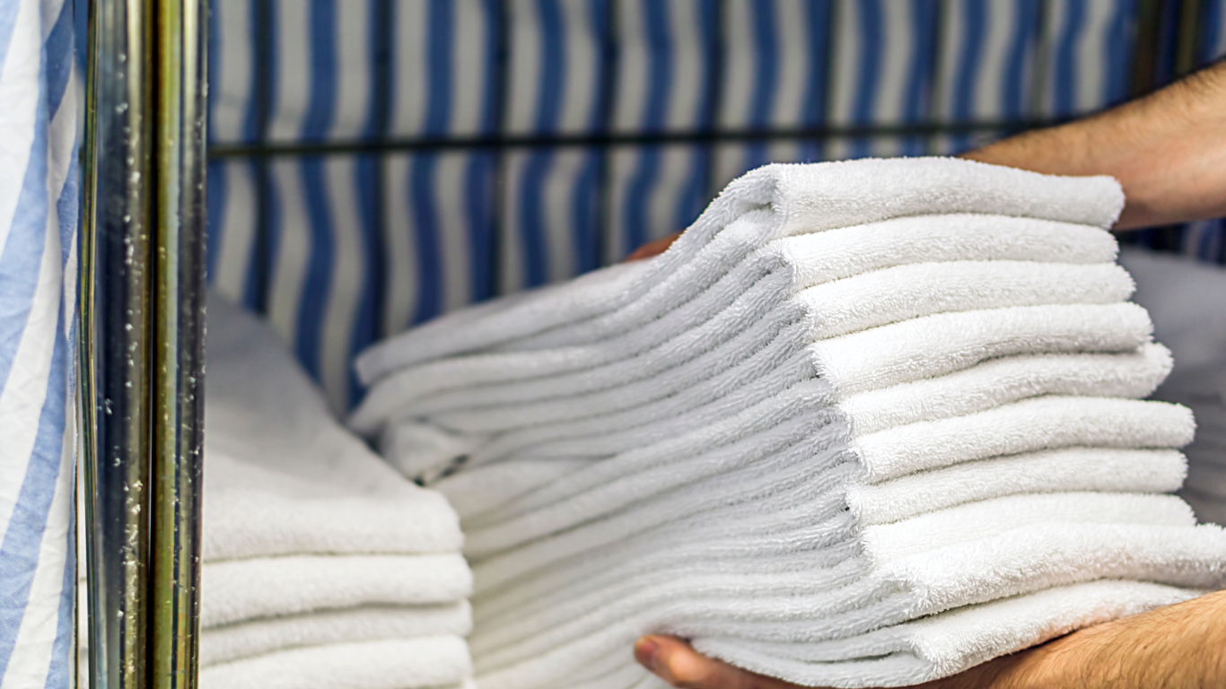 A pile of white towels stacked on top of each other on a table.