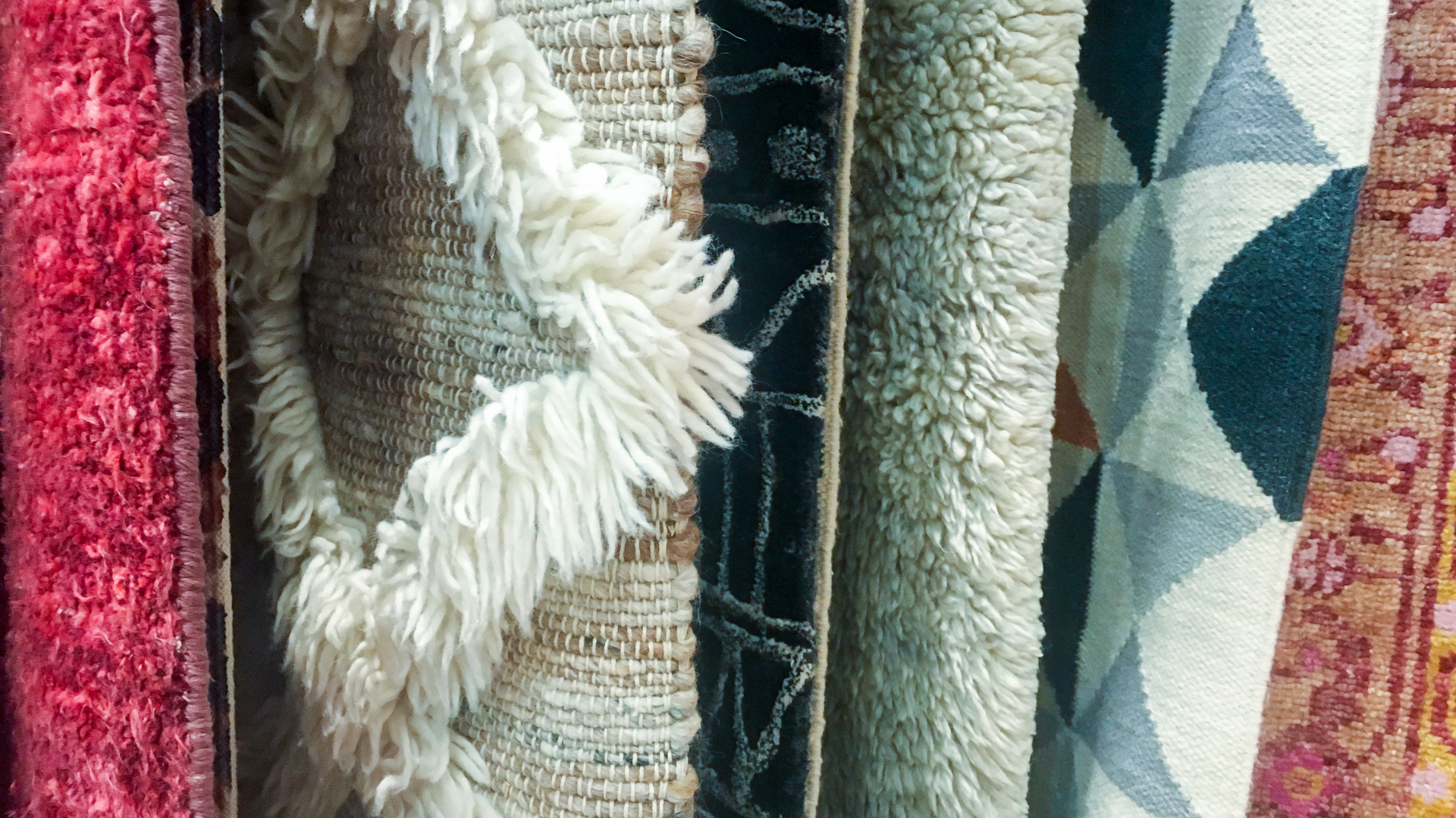 A bunch of rugs are stacked on top of each other.
