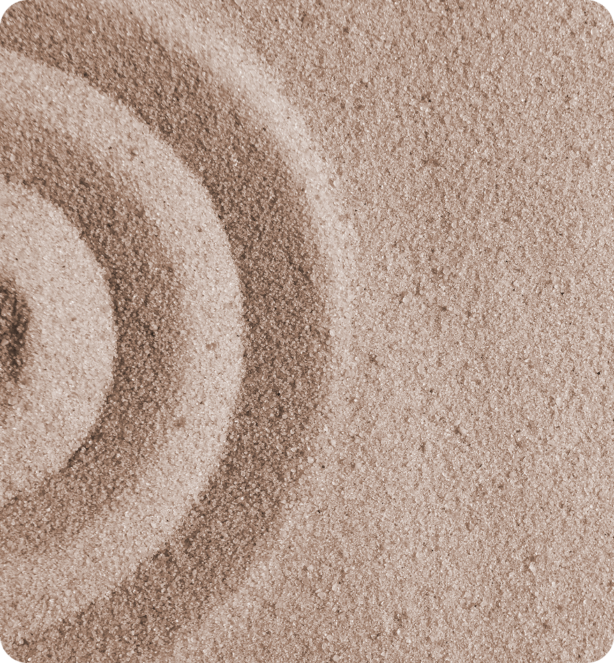Concentric circles raked into tan sand.