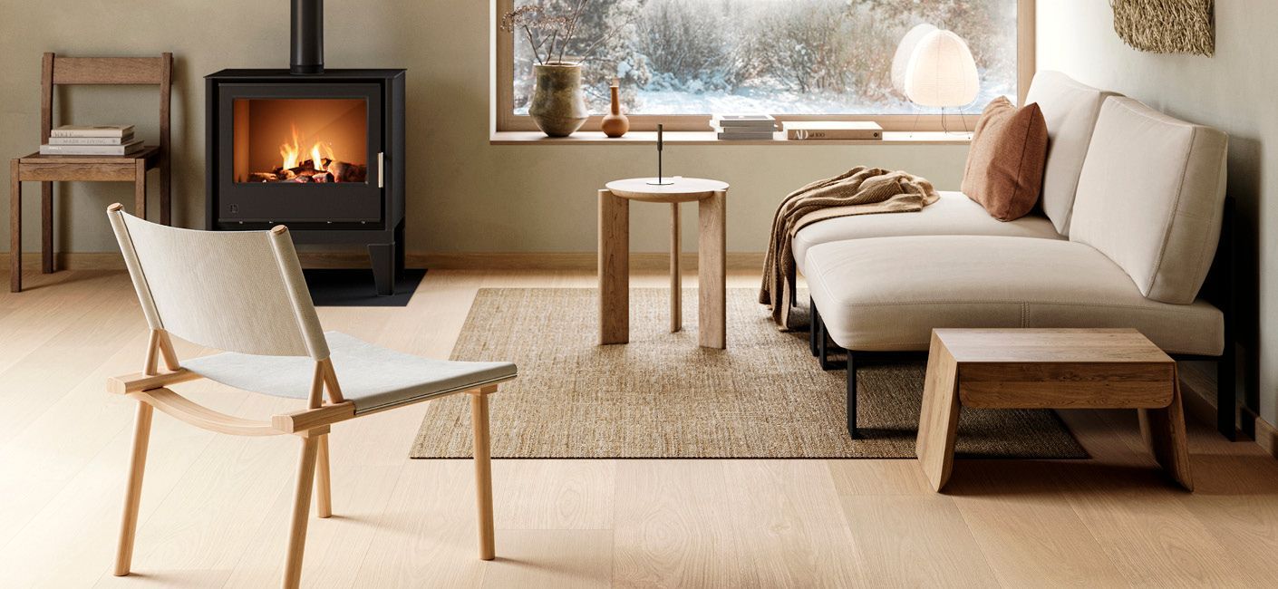 Notaleg stofa með kveiktum arni, beige sófa, tréstól og snjóþöktum glugga með útsýni