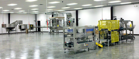 A stainless steel food processing and packaging assembly line in a large.