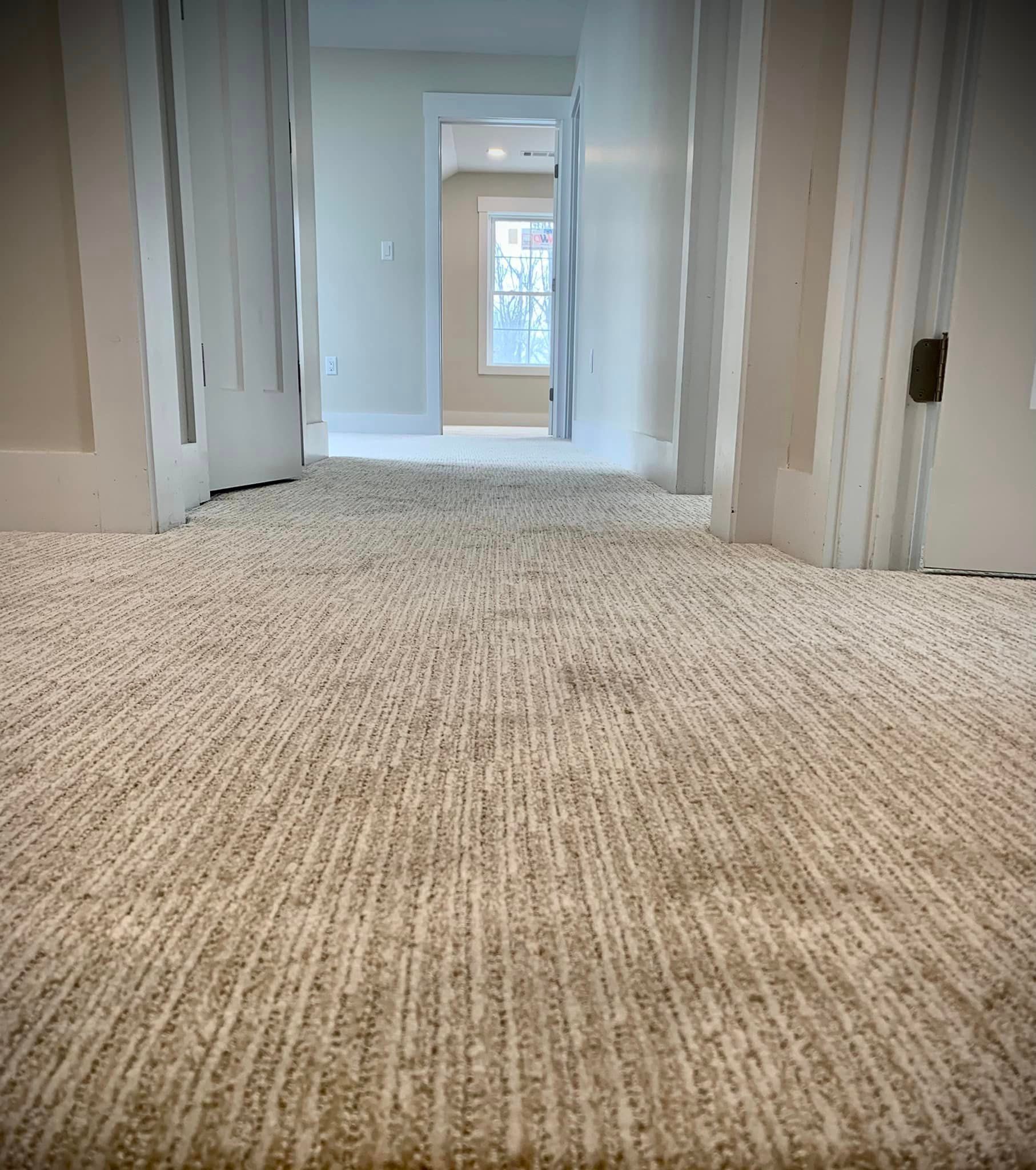 A hallway with a carpeted floor by Floor Source