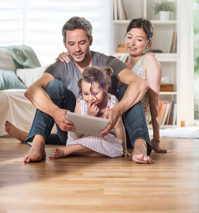 Family looking at tablet on floor of living room