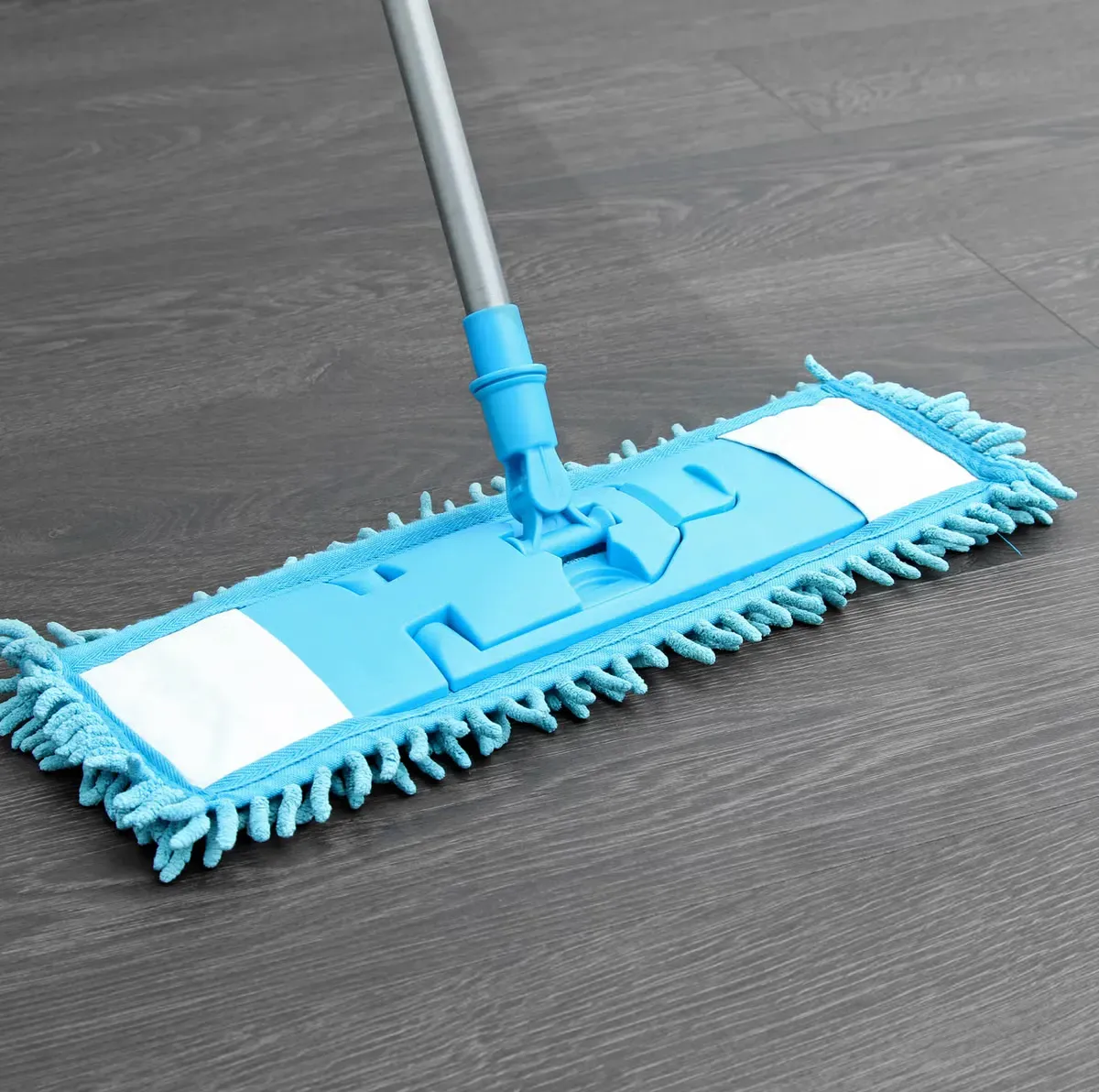 A blue mop is sitting on a wooden floor A blue mop is sitting on a wooden floor