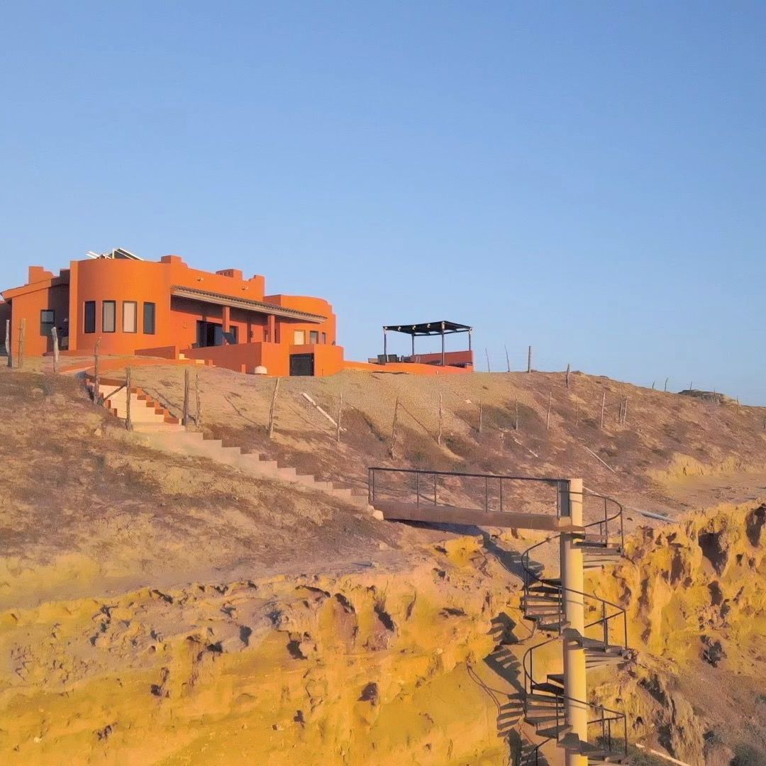 an orange building on top of a hill with stairs leading up to it