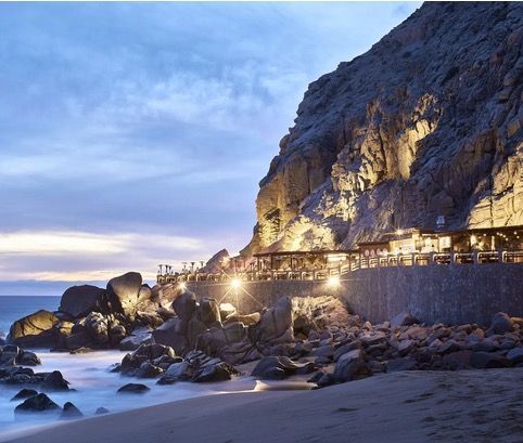 a view of a beach with a cliff in the background
