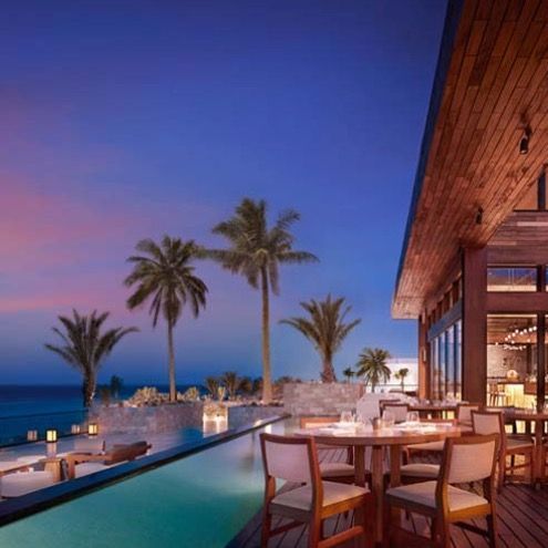 a restaurant with tables and chairs overlooking the ocean